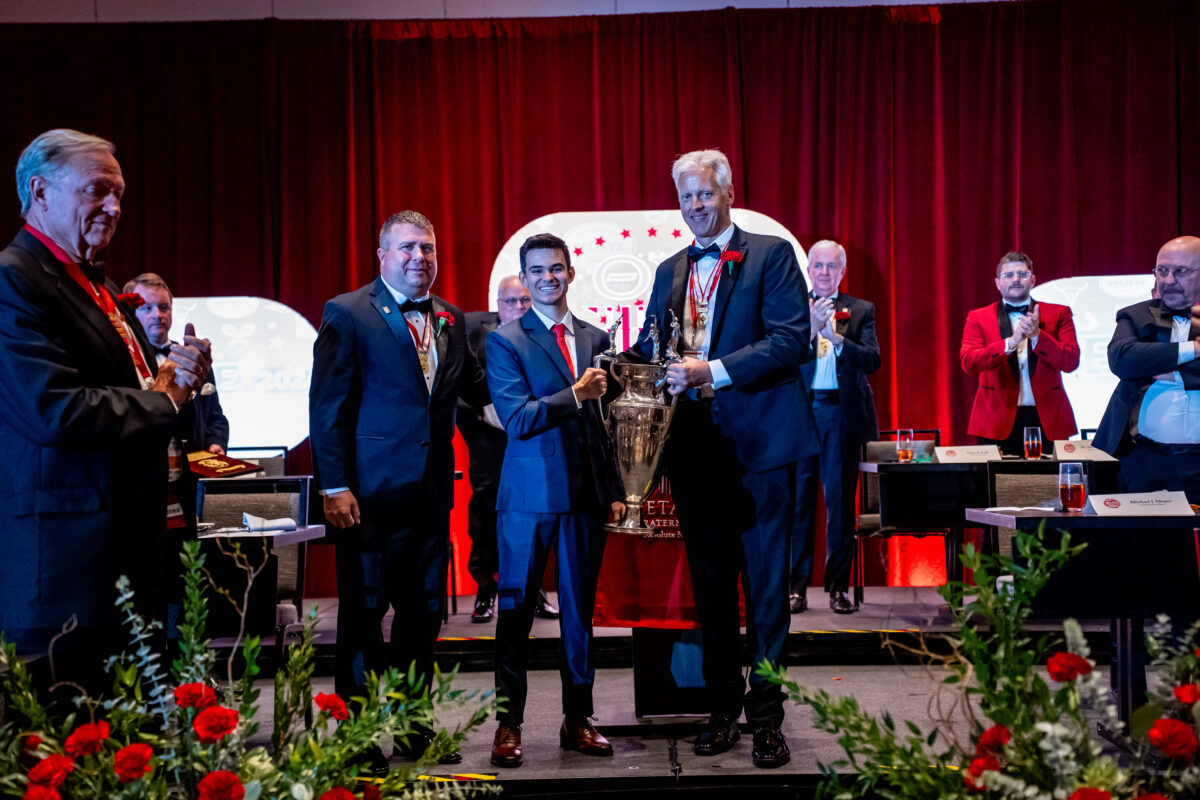 Missouri State's Carlos Abrams holding the Colley Trophy alongside Past Colley Award winners, Mike Mayer and Tom Thompson.