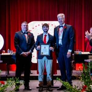 Hunter Lynch holding his Colley award next to Past Colley recipients Tom Thompson and Mike Mayer