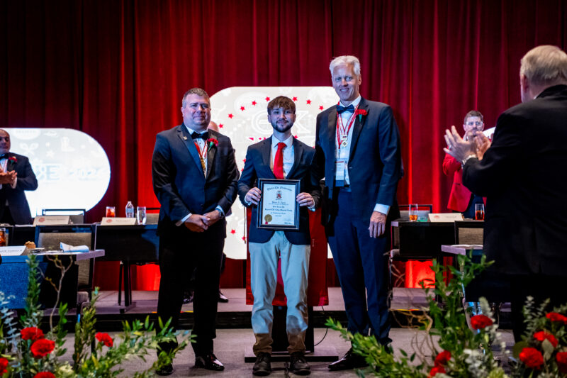 Hunter Lynch holding his Colley award next to Past Colley recipients Tom Thompson and Mike Mayer
